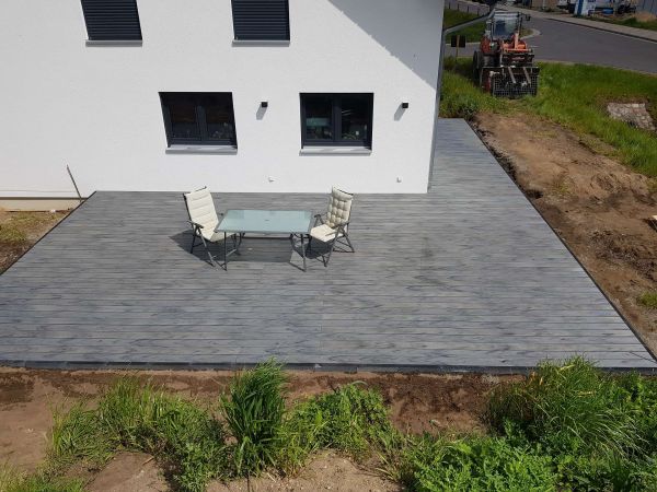 Terrasse mit Tisch und 2 Stühlen vor Haus